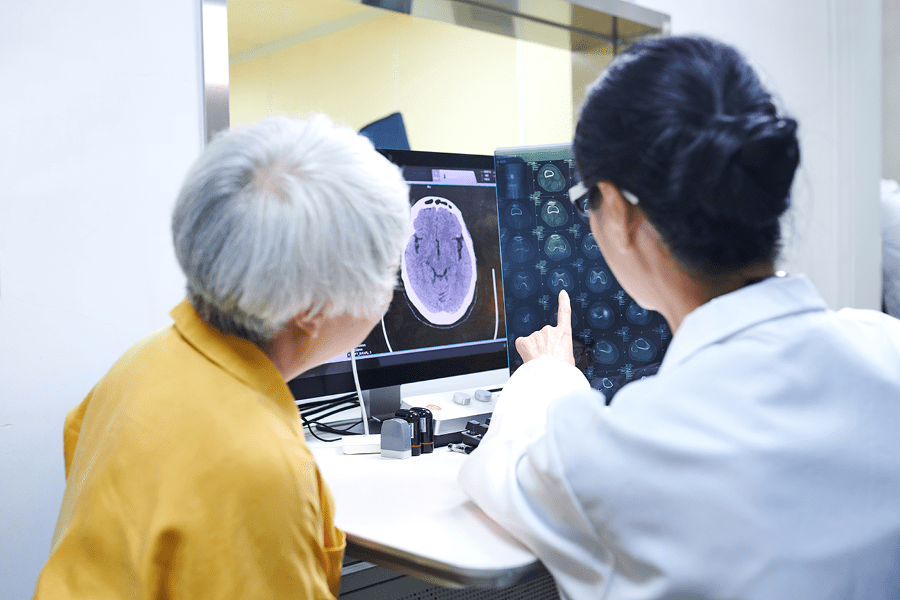 Older adult and doctor looking at a brain scan.