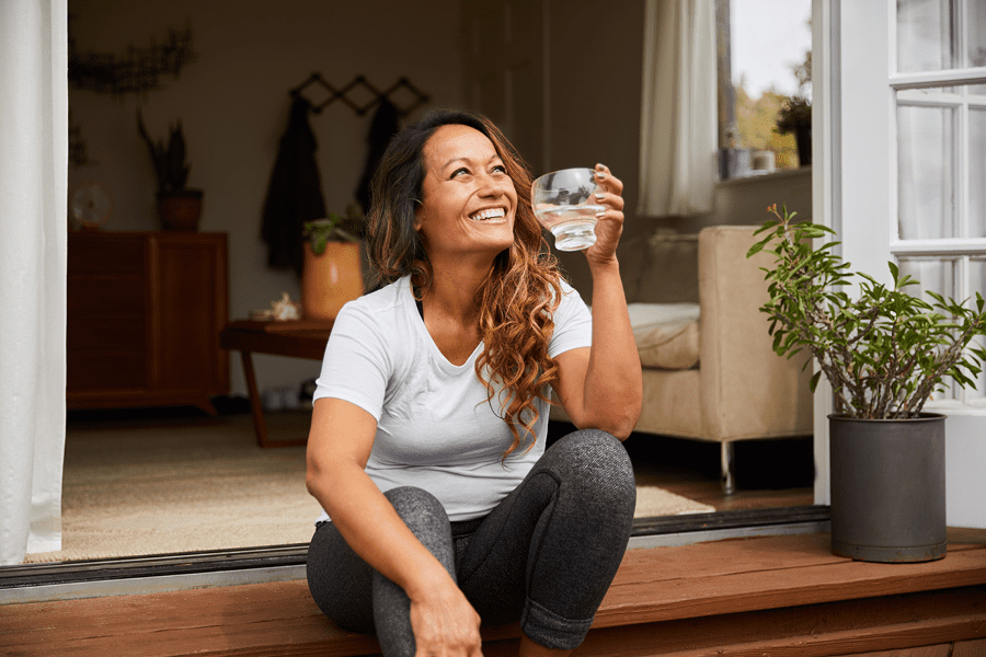 Person drinking water and smiling.