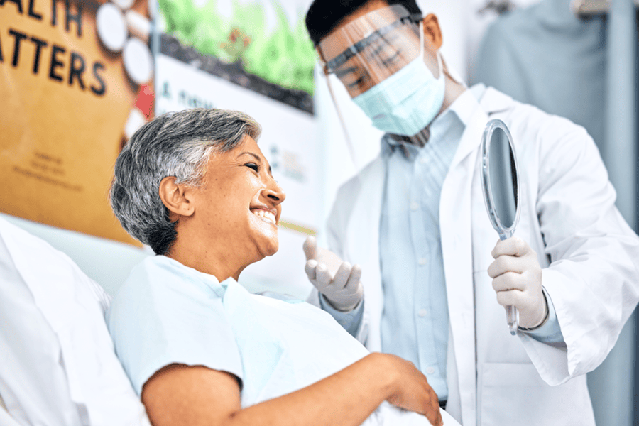 Dentist giving a dental exam to an older adult.